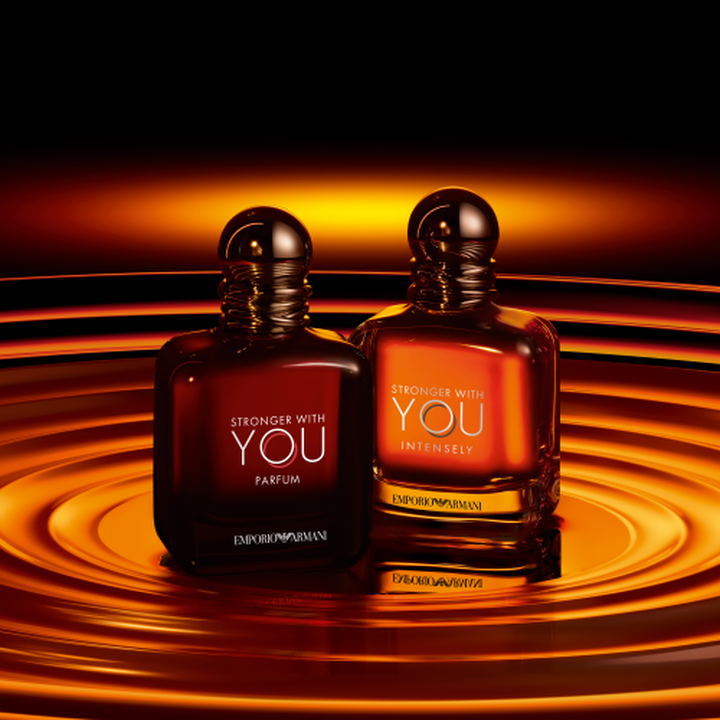Emporio Armani Stronger With You Parfum und Stronger With You Intensely Flakons, warme Bernsteintone vor wirbelndem goldenem Wellenhintergrund
