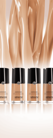 A sleek red perfume bottle by Giorgio Armani against a vibrant red background, exuding elegance and allure.