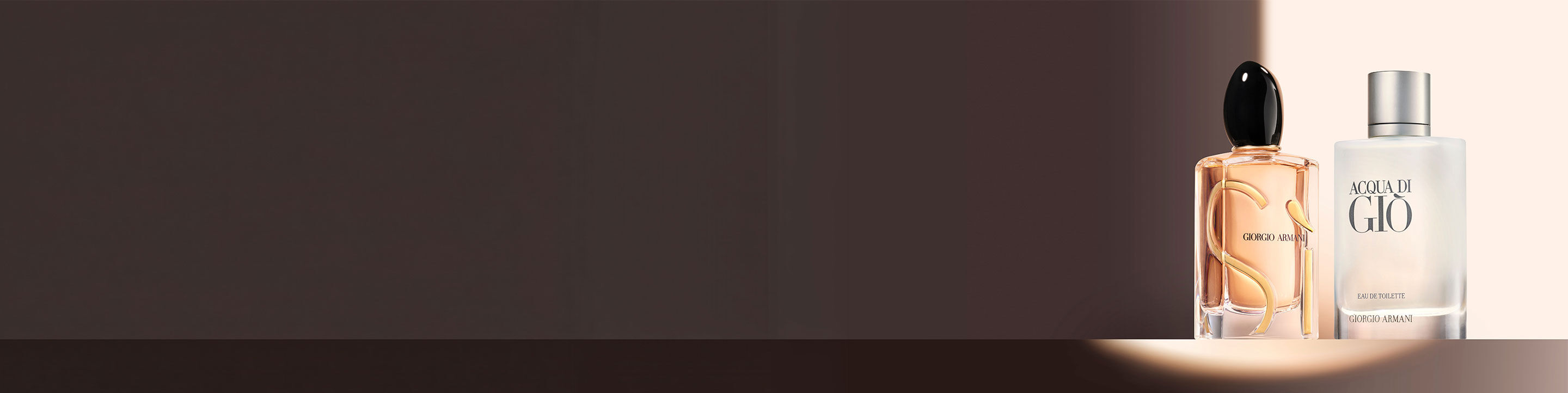 Two elegantly designed perfume bottles sit atop a textured red background adorned with shimmering golden beads, creating a luxurious and captivating display.