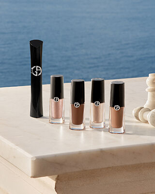 Armani Augen-Essentials: Mascara und Eye Tints mit Schachfiguren auf Marmor vor dem Meer. Ein Symbol fur strategische Schonheit und muhelose sommerliche Eleganz fur eine strahlende Ausstrahlung des Hauses.