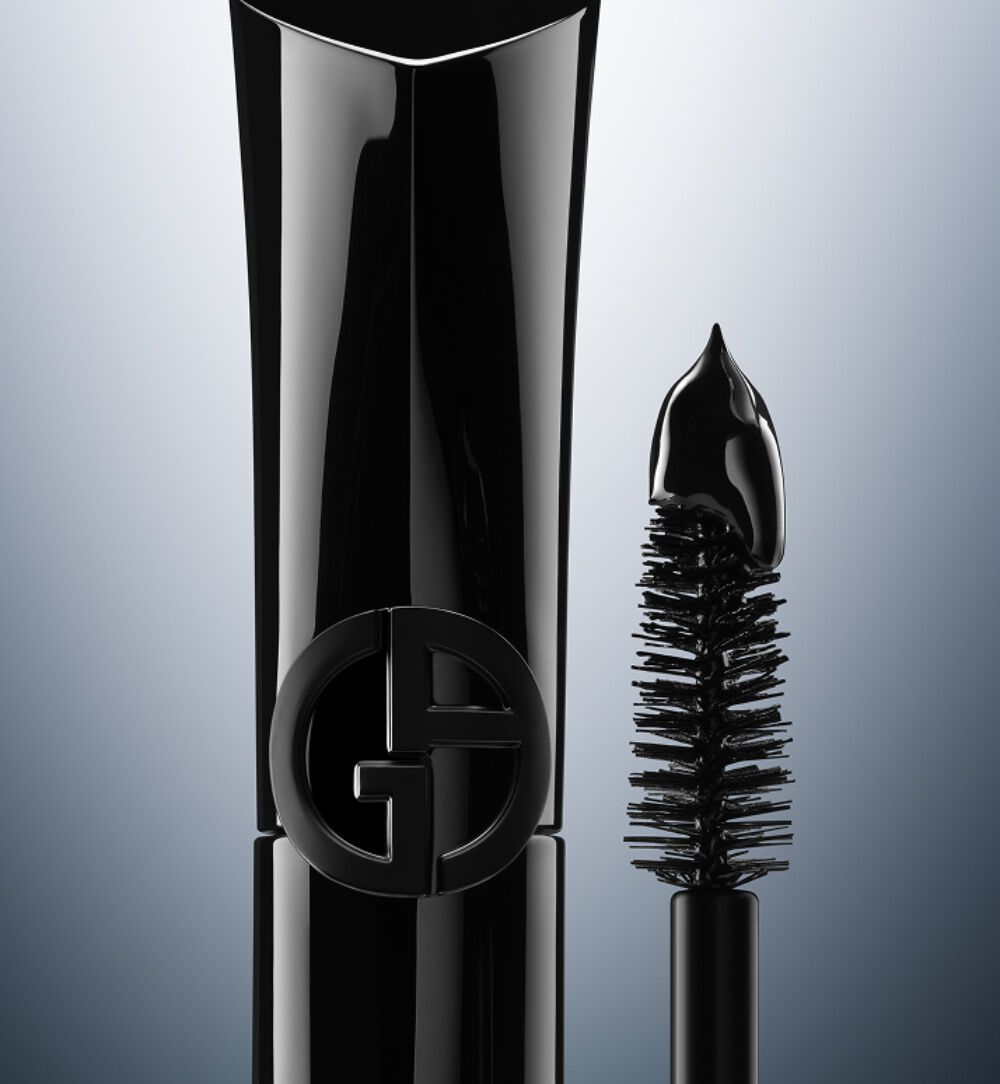 Giorgio Armani Vertigo Drama Mascara in elegantem schwarzem Design, mit geschwungener Burste vor grauem Verlaufshintergrund.