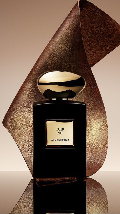 Armani/Prive Cuir Nu: ein eleganter schwarzer Flakon mit goldenem Verschluss, umhullt von einem strukturierten Lederband, der die Sinnlichkeit nackter Haut und die Raffinesse einer holzigen Ledernote verkorpert.