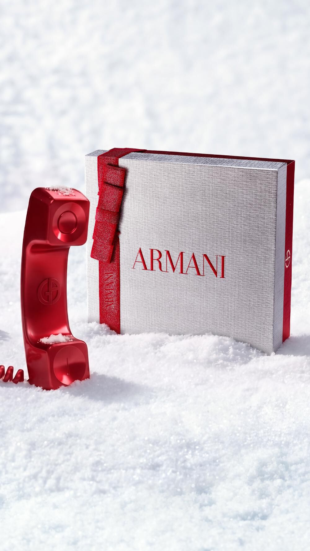 Armani Beauty Weihnachtsgeschenkbox mit einem roten Telefon als Symbol fur den Kundenservice in einer verschneiten Kulisse.