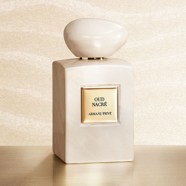 Armani/Prive Oud Nacre: ein irisierender, perlmuttfarbener Flakon auf einem goldenen Sockel vor schimmerndem Hintergrund. Eine lichtvolle Hommage an die edle Kostbarkeit von Oud und die exzellente Handwerkskunst der Armani Haute Parfumerie.