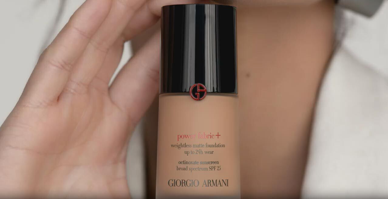 A person holding a bottle of Giorgio Armani Power Fabric+ weightless matte foundation with SPF 25.
