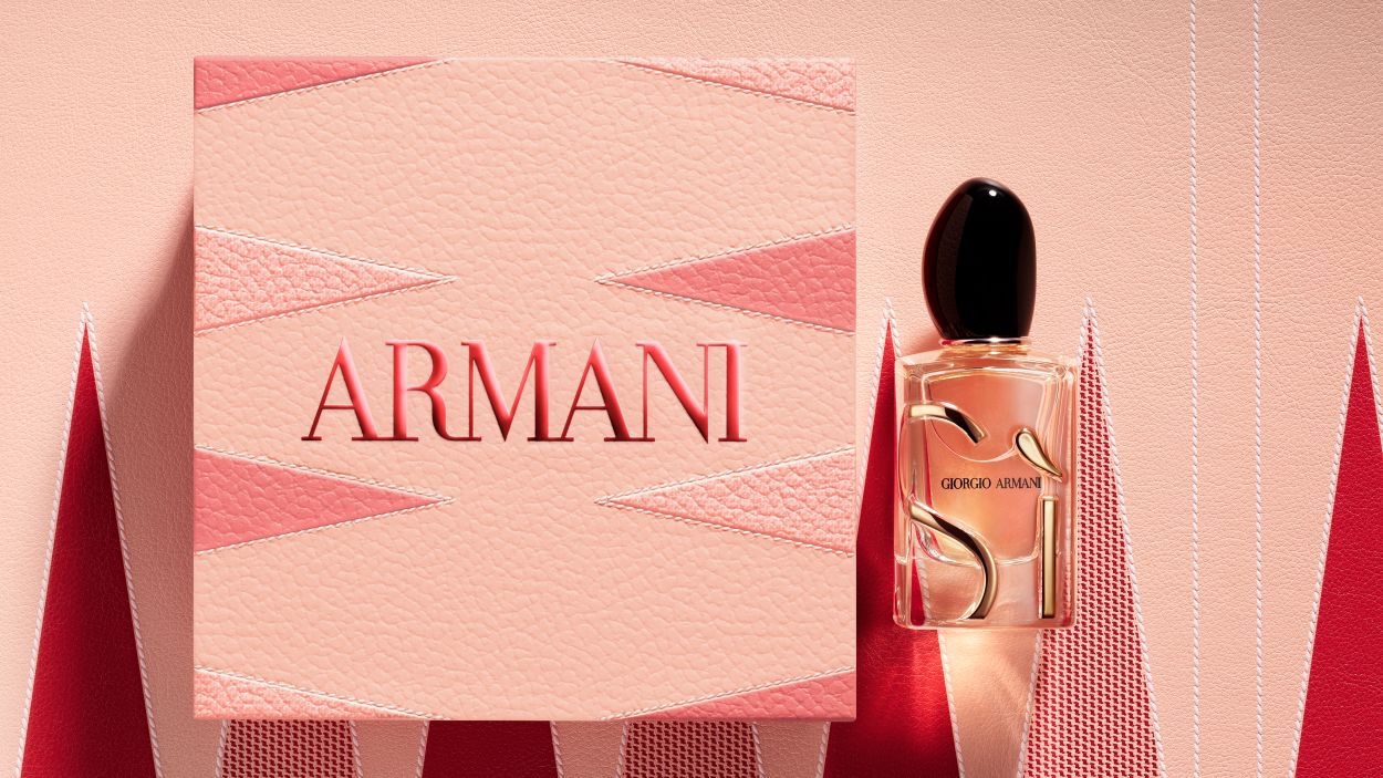 Parfumflakon Giorgio Armani „Si“ neben einer großen, texturierten rosa Armani-Geschenkbox.