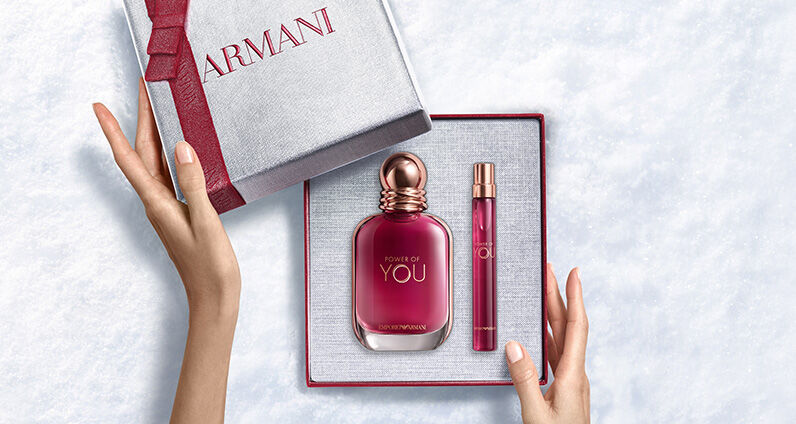 Parfumflakon Giorgio Armani „Si“ neben einer großen, texturierten rosa Armani-Geschenkbox.