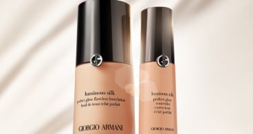 Zwei Flaschen Giorgio Armani Luminous Silk Foundation auf rotem Hintergrund, elegant und stilvoll angeordnet.